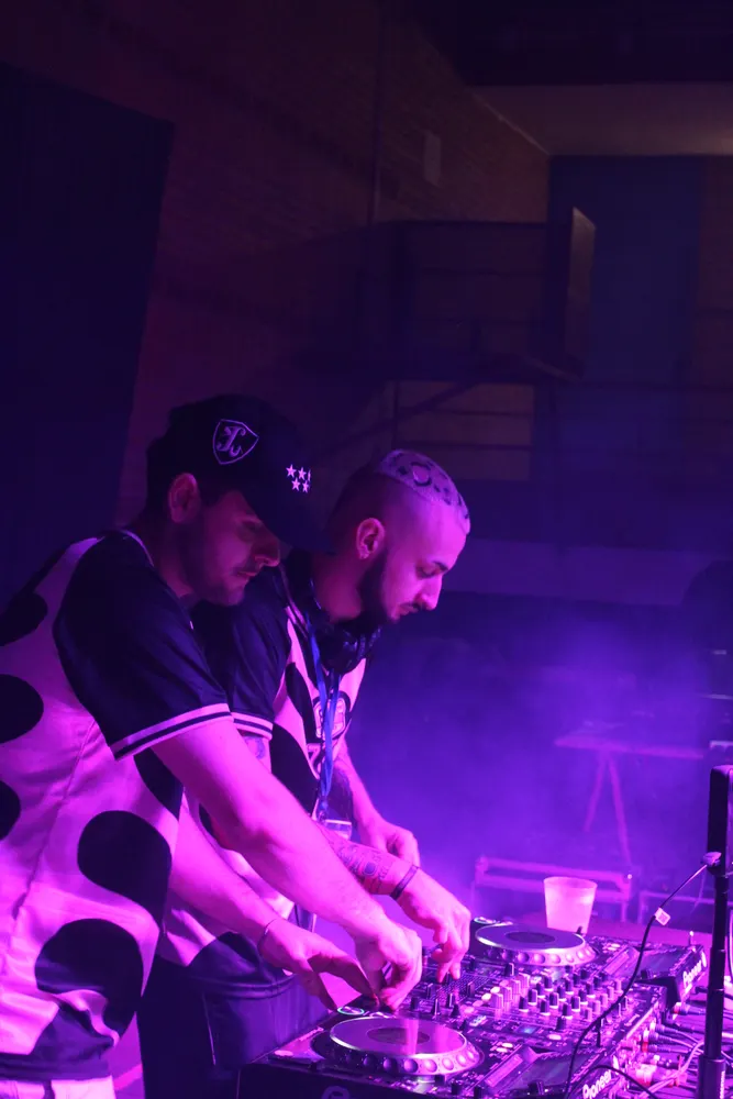 DJs pinchando con luz morada
