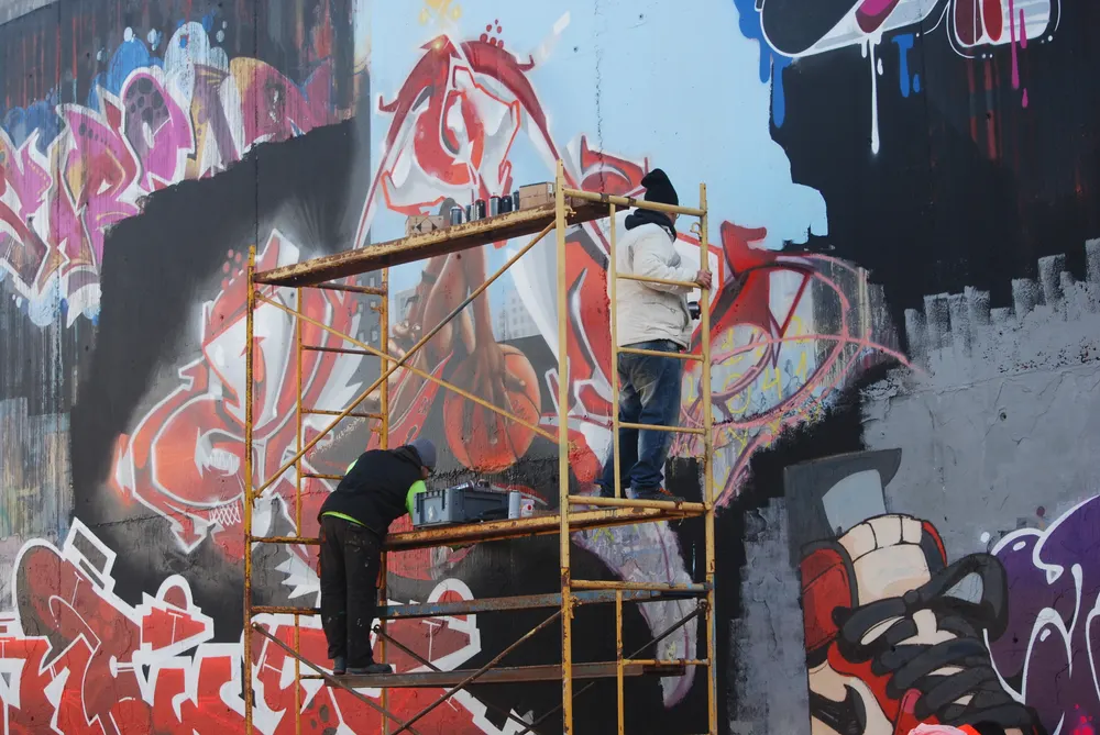 Graffiteros pintando en el andamio