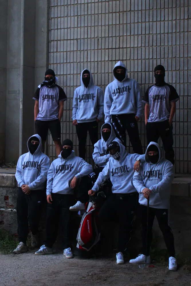 Grupo con sudaderas Lemon Wear grises sentado junto a una pared