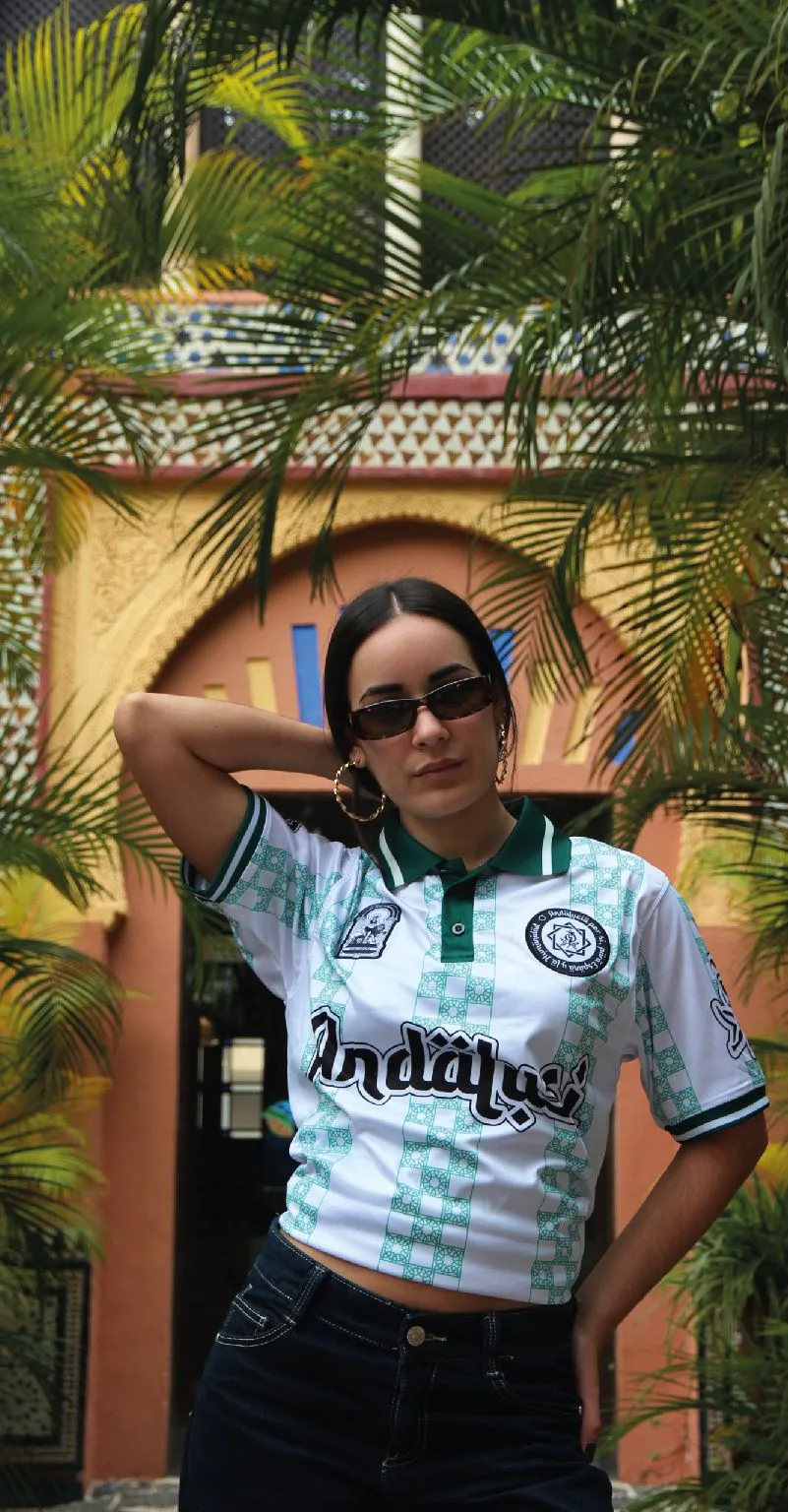 Chica con el polo Andalusí blanco y verde frente a un arco andaluz